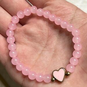 Pink bracelet with a heart in the middle.